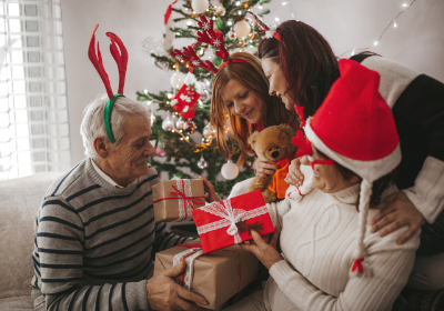 festive holiday family holding christmas gifts looking happy